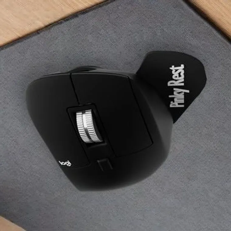Illustration: the pinky rest kit on the right side of a black Logitech MX Master, on a desk pad